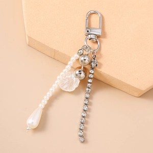 Detail of keychain with pearl strands, rhinestone chain, and white shell pendant decor