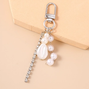 Detail view of silver lobster clasp with rhinestone chain and pearl shell charms
