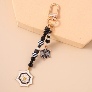Detail of Halloween keychain with black beads, white pearls and spider web pendants