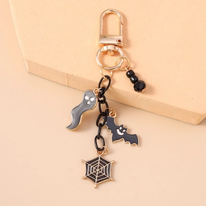 Detail view of Halloween keychain featuring a ghost, bat, and spider web charms with beads