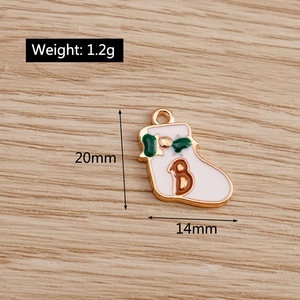 Detail of white enamel Christmas sock pendant with gold trim for jewelry making