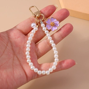 Close-up of pearl bead strap with purple enamel flower pendant and golden D-ring hook