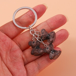 Porte-clés créatif avec oursons 3D marron foncé et nœuds noirs sur un anneau en métal argenté