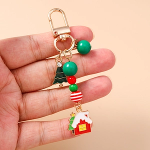 Dettaglio portachiavi natalizio con ciondolo a casetta, albero di Natale e perle colorate