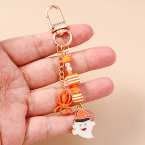 Detail of Halloween ghost keychain with orange spider charm and striped beads on gold link