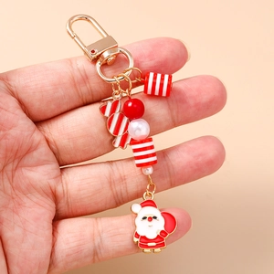 Macro di ciondolo Babbo Natale smaltato e perline a strisce su un portachiavi dorato