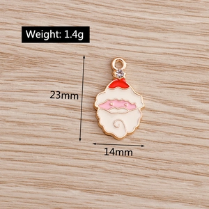 Enamel Santa Claus pendant showing 23mm height and 14mm width dimensions on wood background
