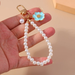 Detail of beaded pearl keychain with light blue enamel flower pendant and gold lobster clasp