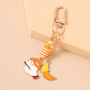 Close-up of cute ghost keychain with orange star hat, moon charm, and striped beads