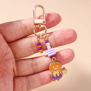 Gros plan d'un pendentif sorcière citrouille d'Halloween avec perles violettes et orange