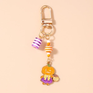 Détail du porte-clés d'Halloween avec perles rayées et pendentif citrouille de sorcière