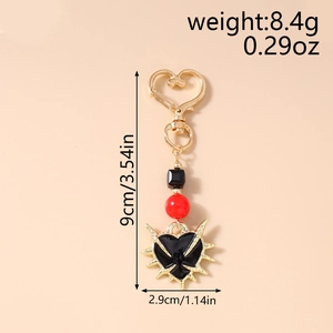 Gothic punk heart keychain with gold thorns, red beads and dimensions 9cm by 2.9cm