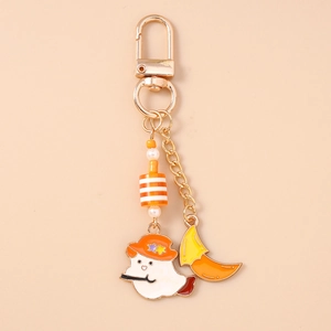 Detail of banana spider keychain with enamel ghost and orange moon pendant charm