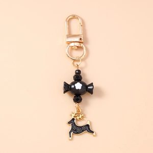 Close-up of black candy bead and golden reindeer pendant on creative holiday keychain