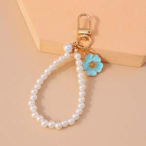 Detail of elegant pearl keychain with blue floral pendant and golden lobster clasp
