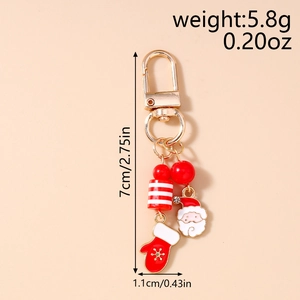 Détail du porte-clés de Noël avec charm Père Noël et gant de flocon de neige émaillé