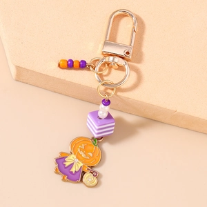 Détail de porte-clés d'Halloween avec perles rayées et pendentif de sorcière citrouille
