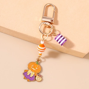 Détail du porte-clés citrouille d'Halloween avec perles rayées violettes et fermoir doré