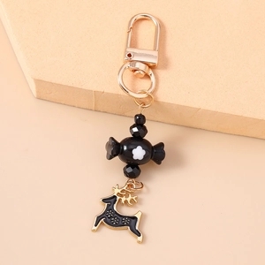 Detailed close-up of a black and gold reindeer keychain with floral patterned bead