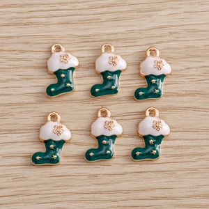 Detail of Christmas stocking pendants with green enamel and gold stars for DIY jewelry