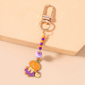 Détail d'un porte-clés d'Halloween avec perles orange et pendentif citrouille en robe mauve