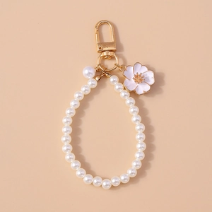 Elegant white pearl wristlet keychain with gold spring clasp and enamel flower pendant