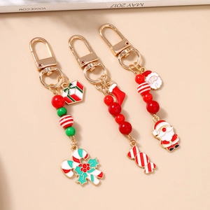 Détail de trois porte-clés de Noël avec charms Père Noël, canne en sucre et boîte cadeau