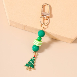 Detail view of a Christmas tree keychain with green beads and gold lobster clasp