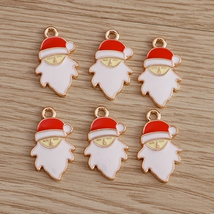Macro shot of six enamel Santa Claus charms for DIY jewelry making on wood surface