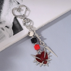 Detail of gothic sword and heart keychain with red thorn heart pendant and silver heart clasp