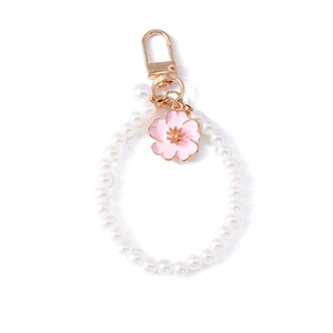 Elegant cherry blossom pearl keychain with gold-tone hardware and pink enamel flower charm