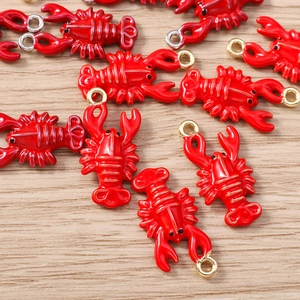 Detailed view of red lobster charms for DIY jewelry making with gold and silver rings