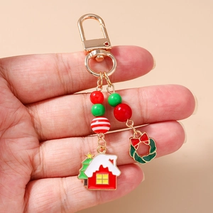 Vue détaillée du porte-clés de Noël avec anneau en D doré, perles, breloques maison et couronne