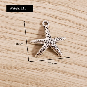 Macro detail of a vintage silver starfish pendant with textured holes and top hanging ring