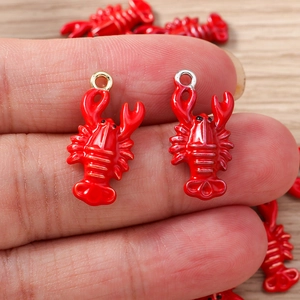 Detail of a red enamel lobster charm held in hand for DIY jewelry making and crafts