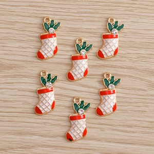 Detail of Christmas sock charms in red and white enamel with gold trim and rhinestones