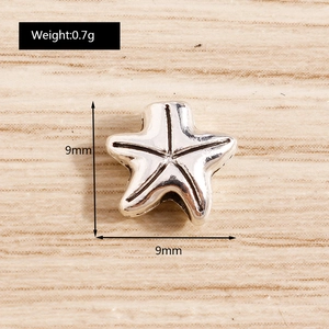Macro shot of 9mm silver starfish pendant with radial texture for jewelry making