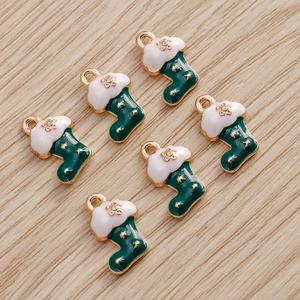 Detail of dark green Christmas sock pendants with golden stars on wooden surface