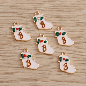 Detail of Christmas sock pendant with letter B, green leaves, and gold metallic edging