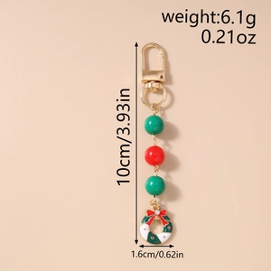 Detail view of Christmas wreath keychain with red bow, green beads and golden clasp
