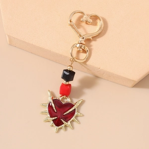 Gothic heart keychain detail featuring red heart pendant with golden spikes and square beads