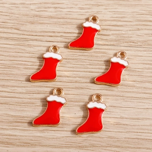 Macro view of five red enamel Christmas sock pendants with gold alloy edges for DIY jewelry