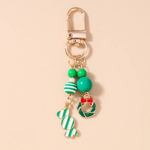 Détail d'un porte-clés de Noël avec bonbon rayé, couronne et fermoir mousqueton doré
