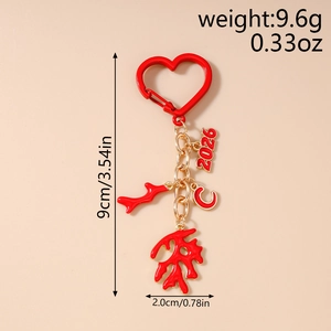 Detail of red enamel heart keychain with 2026 and coral charms on gold-tone chain