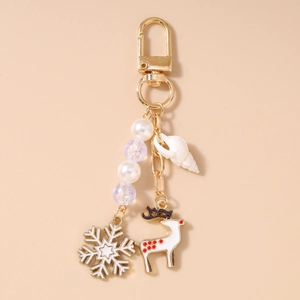 Detailansicht eines goldenen Weihnachts-Schlüsselanhängers mit Muschel und Rentier-Motiv