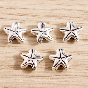 Detailed view of five vintage silver starfish charms with intricate metal textures