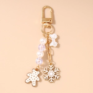 Detailansicht goldener Schlüsselanhänger mit Perlenbär, Schneeflocke und Schleife
