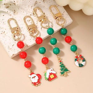 Set of 4 Christmas keychains with Santa Claus and wreaths on a white stone background