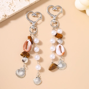 Détail d'un porte-clés bohème avec fermoir coeur, perles, coquillages et oeil de tigre