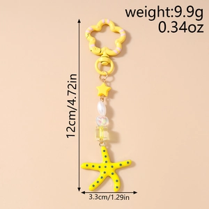 Detailweergave van gele zeester sleutelhanger met afmetingen 12cm lengte en 9,9g gewicht